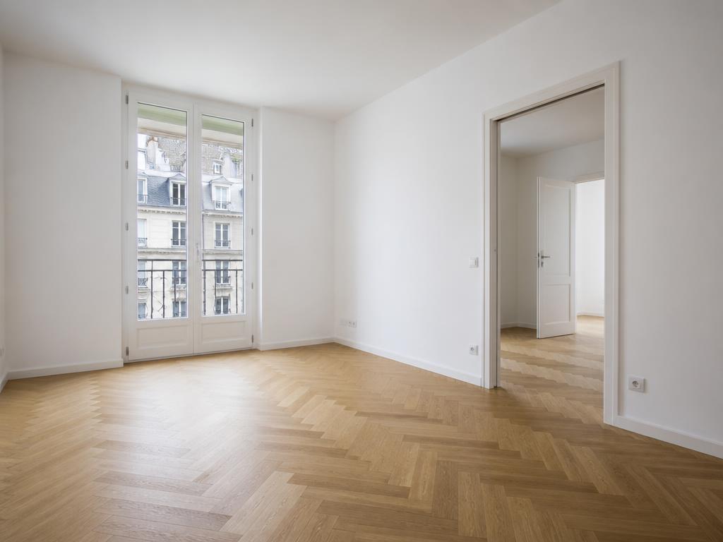 Pièce rénovée avec murs peints et parquet neuf